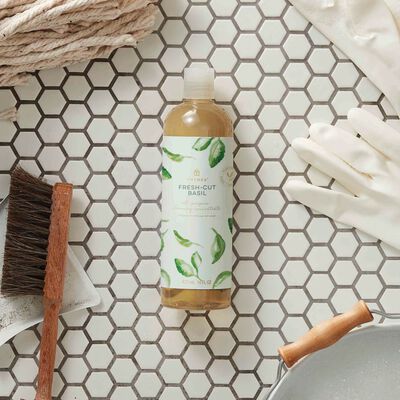 Thymes Fresh-Cut Basil All-Purpose Cleaning Concentrate for Floors and Surfaces laying on bathroom tile
